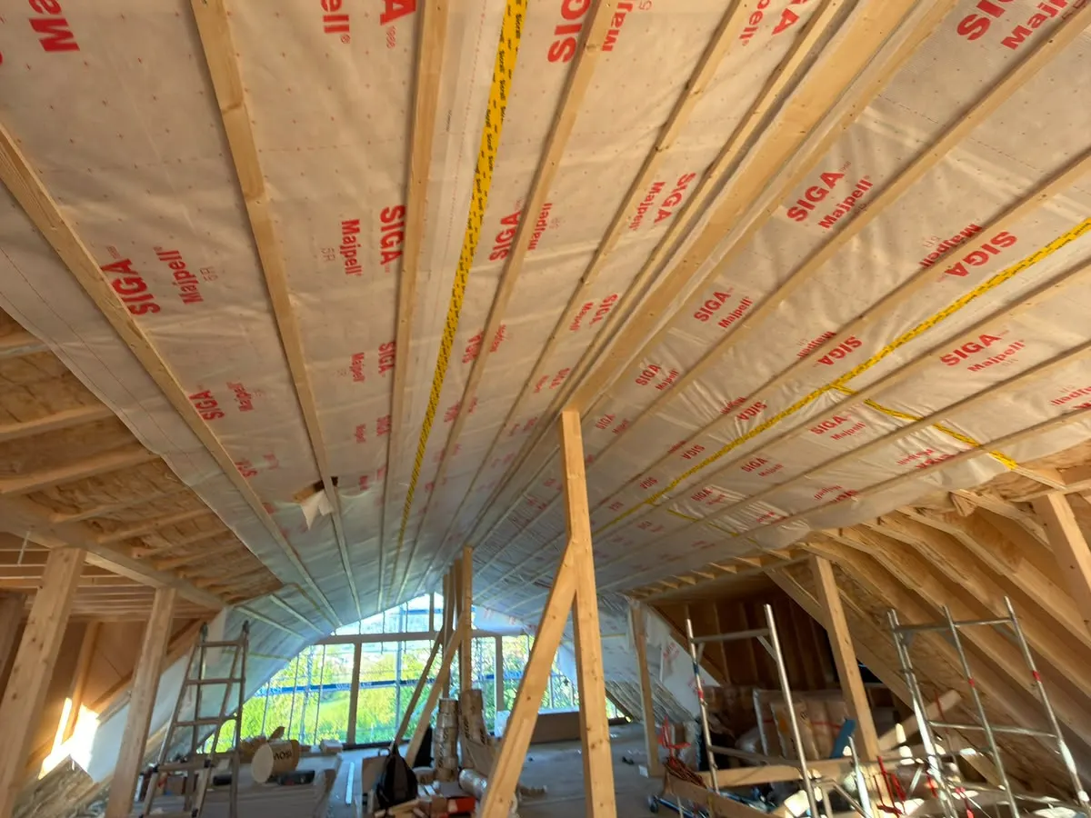 Dachstuhl mit Holzsparren und Dampfbremse vor dem Ausbau