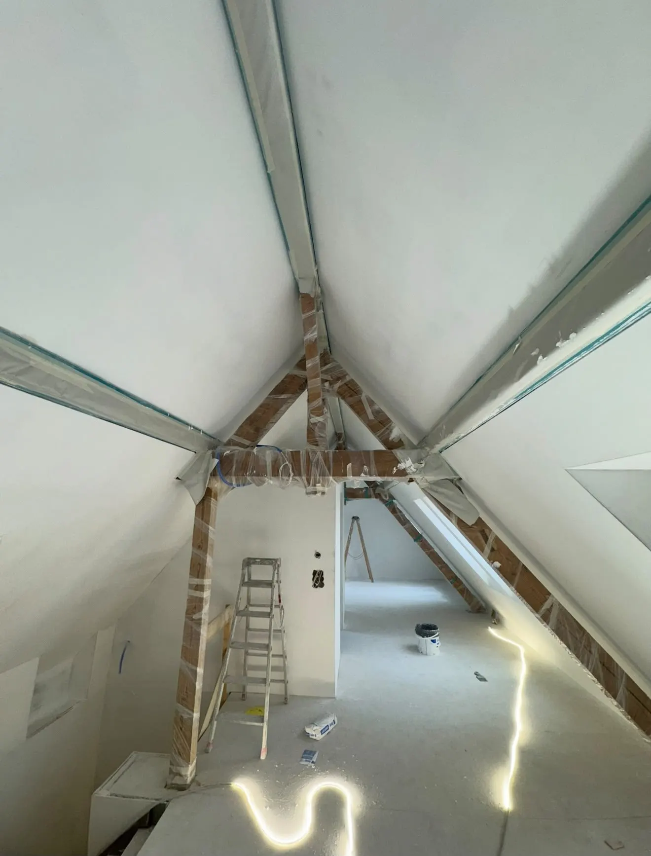 Gespachtelter Dachspitz mit eingepackten Holzbalken