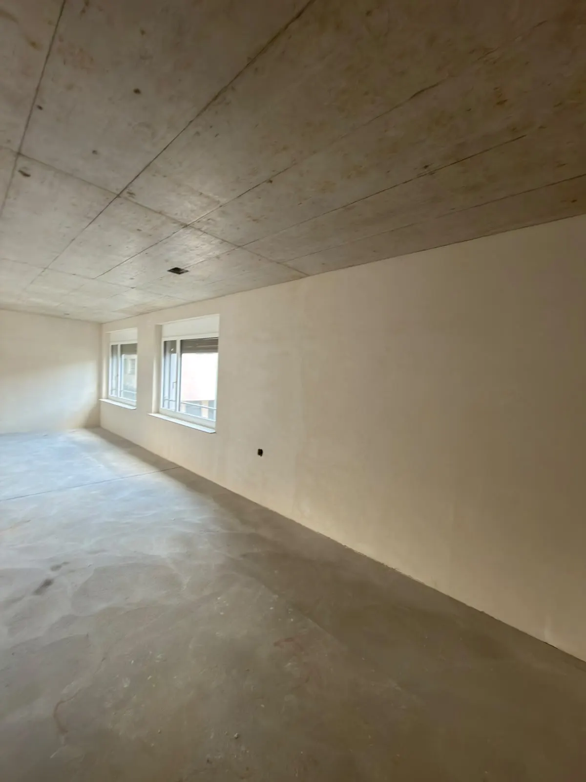 Frisch grundverputzter Raum mit Fensterfront