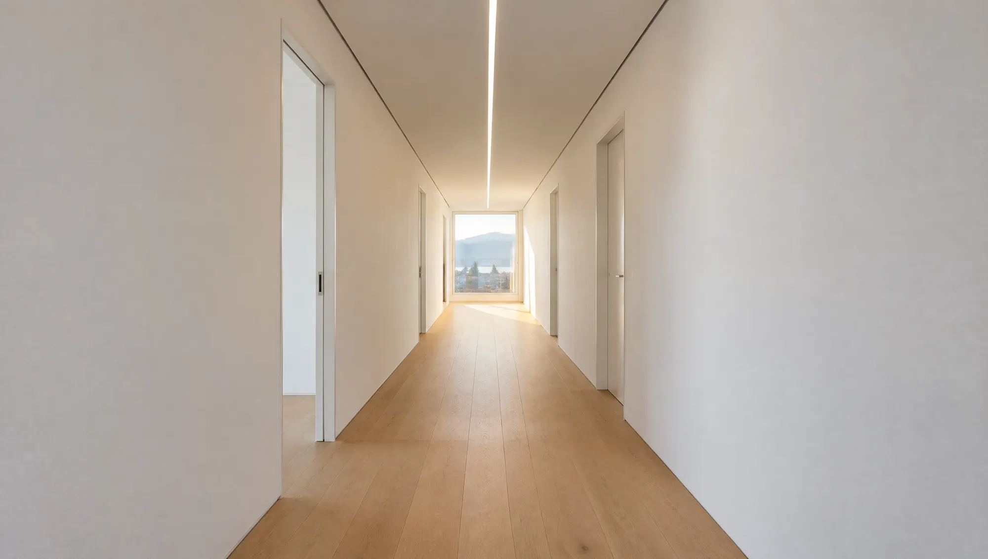Fertiger Korridor mit weiss verputzten Wänden und abgehängter Decke mit Lichtband